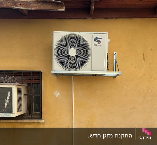 התקנת יחידה חיצונית של מזגן על תושבת מתכת בקיר חיצוני